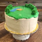 Picture of a cake with golf theme and green icing.