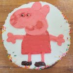 Picture of a pink pig on a cake with icing.